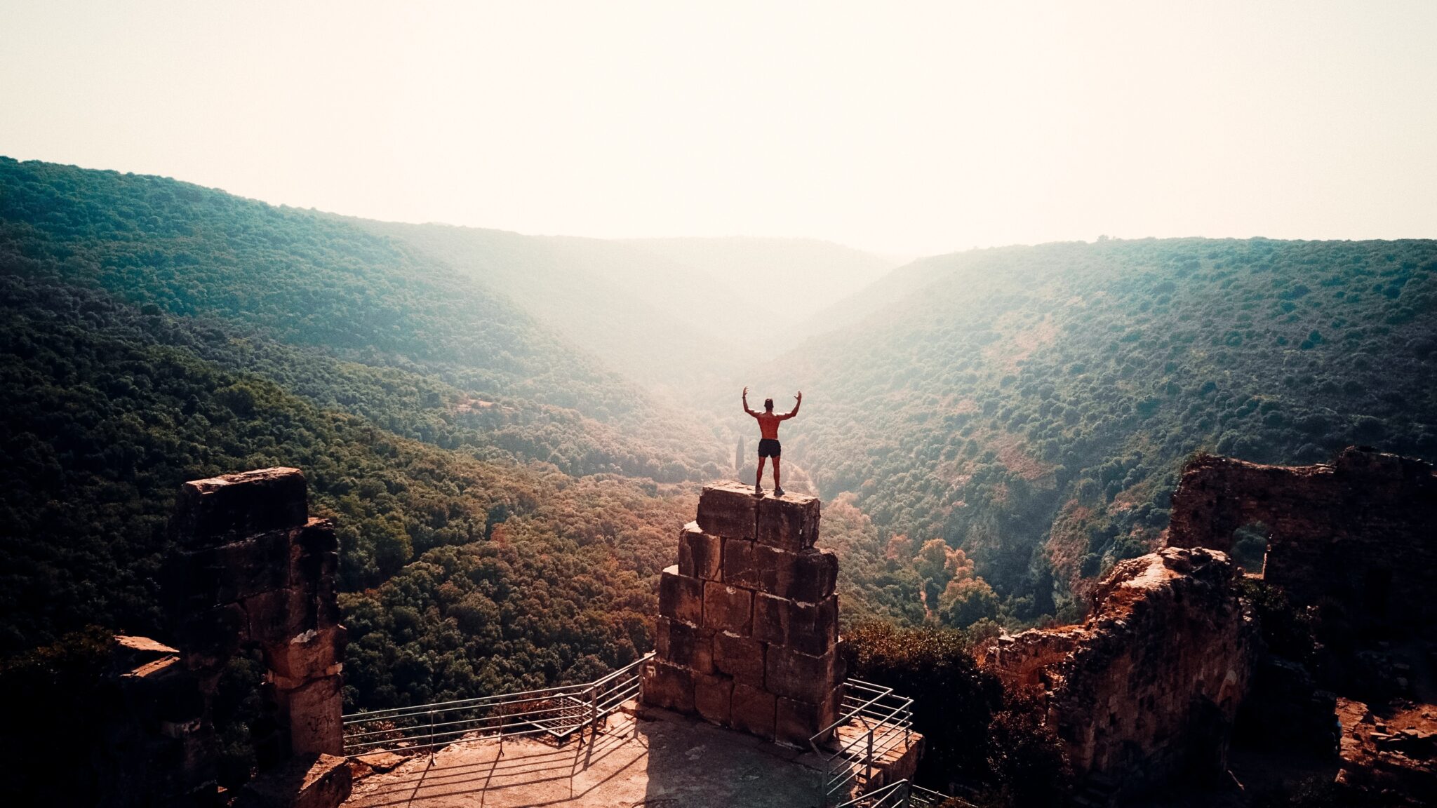 man standing on top of blocks in the mountains